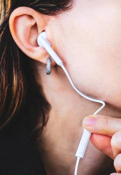 Tocando auriculares prensa volumen fuerza cerrar mujer audio aislamiento — Foto de Stock