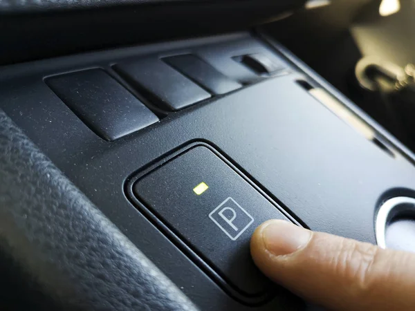 Dedo de la mano presionando el botón del engranaje del parque en el interior del coche de transmisión automática —  Fotos de Stock