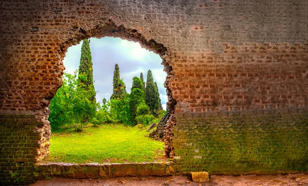 Hole in wall garden eden gate horizontal background broken — Stock Photo, Image