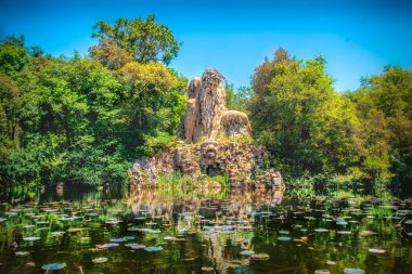 Villa Demidoff Pratolino parkı ve colosso del Appennino suluboya ve yaprakları dolu gölet ile colossus heykeli