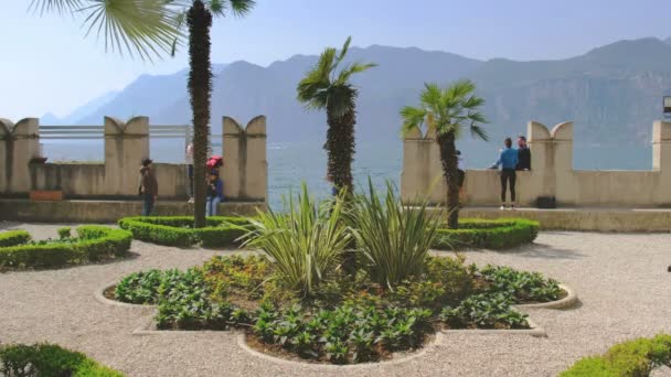 Люди посещают средневековый сад на озере Гарда в Мальчезине, Италия, 25 апреля 2019 года — стоковое видео