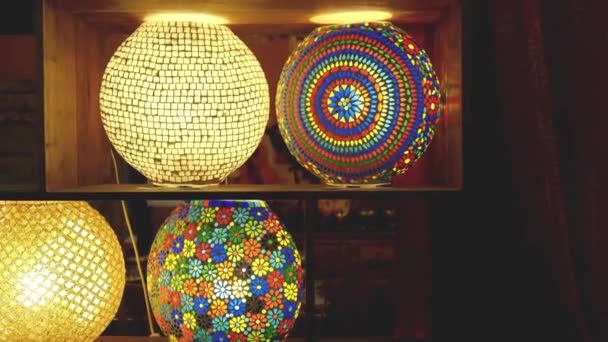 Coloré lampes en verre teinté mosaïque coloré dans des étagères de fond sombre — Video