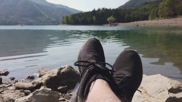 Férfi élvezni pihenni nyugodt tó nézőpont lövés cipő panning háttér — Stock videók