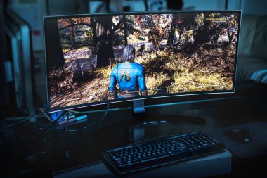 PC gaming concept - an ultrawide screen on a dark room with the Fallout 76 game on it in Bologna, Italy, 04 September 2020 - Illustrative Editorial clipart