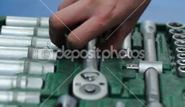 Tamirci, araç kutusundan bir İngiliz anahtarı seçer. Modern araç araba tamir için. Araba servisi