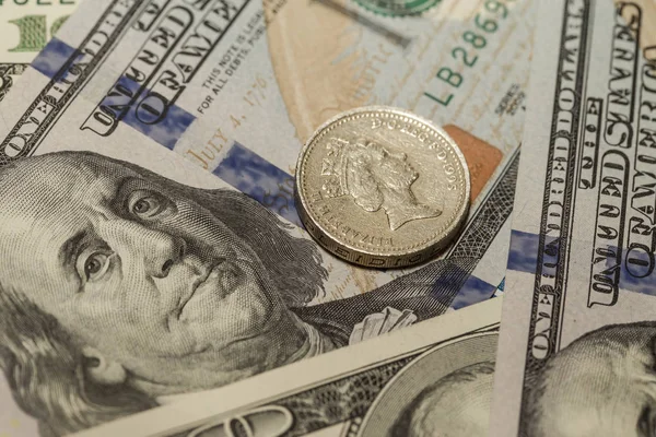Döviz kurları. Yeni Amerikan yüz dolar ve bir İngiliz Lirası içinde bir sikke.