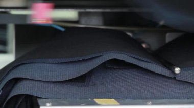 Modern dokuma fabrikası. Bir kadın tezgâh çalışıyor. Ayrıntılar ve makine tasarım unsurları. Teknoloji iş