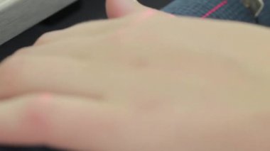 Meslek terzi. Bir modern giyim fabrikası. Bir kadın kumaş parçaları bir dikiş makinesi koyar..