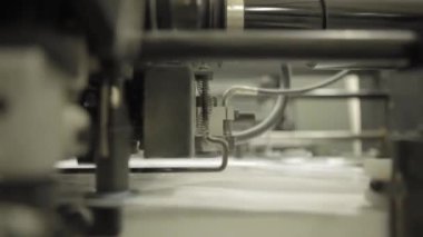 Video kırpmak--dan baskı fabrikası. Makine işleminde kağıt besleme için. Modern ekipman detayları.