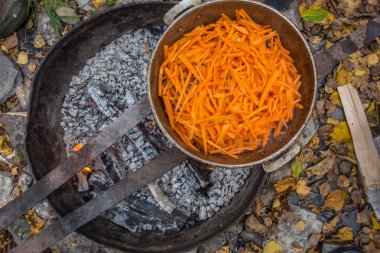 Pilav yanıyor hazırlanması. Havuç kesim. Havuç et ve bir tencerede yağ ile karıştırın.
