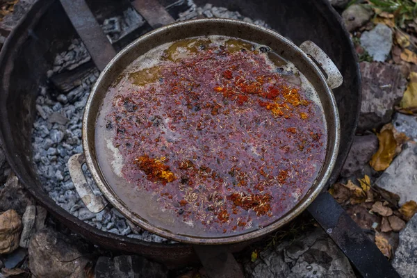 Bir açık ateş üzerinde pişirme pilav. Baharat eklemek için zaman.