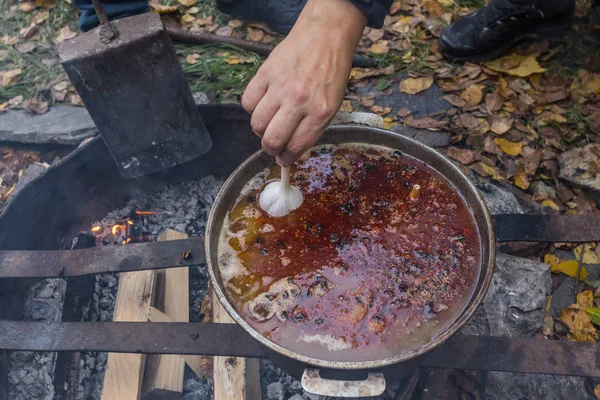 Bir açık ateş üzerinde pişirme pilav. Baharat eklemek için zaman.