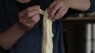 Video klip. Bir kadın bir helezon peynir örgüleri. Chechil ev yapımı peynir üretimi. Modern Rus köy. Rus çiftçi.