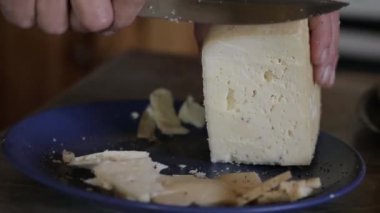 Peynir fabrikası hakkında video klibi. Ev yapımı Sert peynir tatma. Bir kadın büyük bir bıçak ile bir peynir kesiyor.