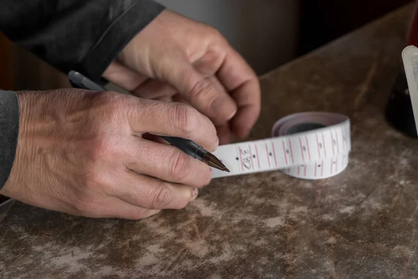 A woman makes notes on sales. Country Cashier