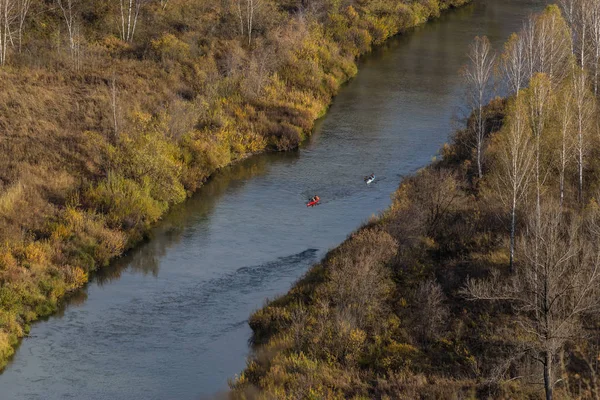 Kayaking on the Siberian river. The change of seasons in Russia. Yellow forest on the banks of the cold river.