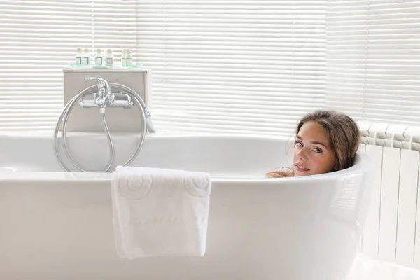 Mulher bonita relaxante deitado em tubo de banho — Fotografia de Stock