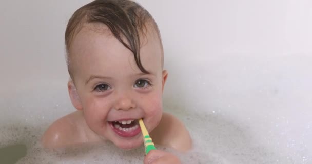 Menino tomando banho em espuma escovando dentes — Vídeo de Stock