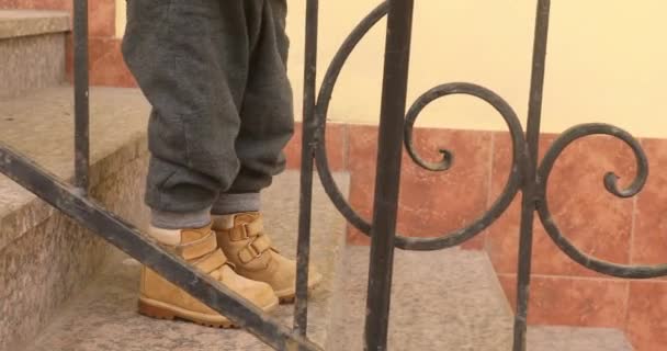 Мальчик спускается по лестнице — стоковое видео