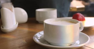 Cappucino bardak gökkuşağı tablo üzerinde parlama ile