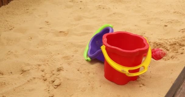 Kinderen speelgoed emmers, spade en schop op zand — Stockvideo