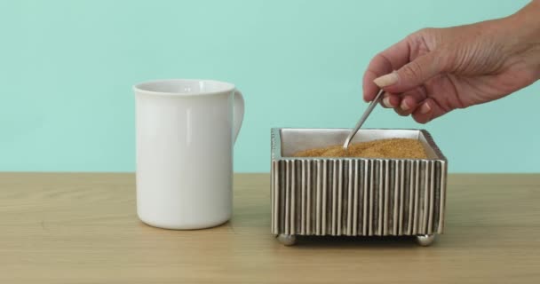 설탕 그릇에서 컵에 설탕을 추가 하는 손 — 비디오