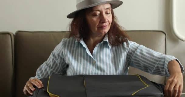 Bejaarde vrouw gaat op vakantie een koffer inpakken — Stockvideo