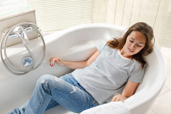 Mujer con ropa acostada en el baño —  Fotos de Stock