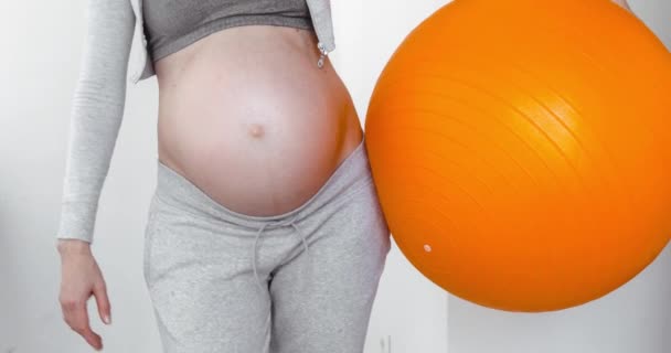 Беременная женщина держит фитнес-мяч — стоковое видео