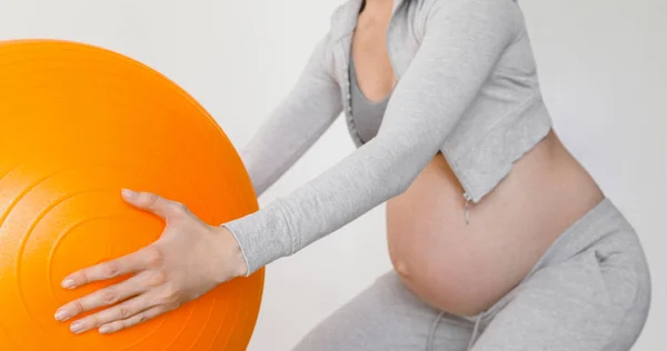 Pregnant woman exercising with fit ball making squats — Stock Photo, Image