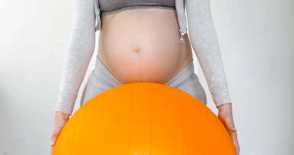 Беременная женщина держит фитнес-мяч — стоковое фото