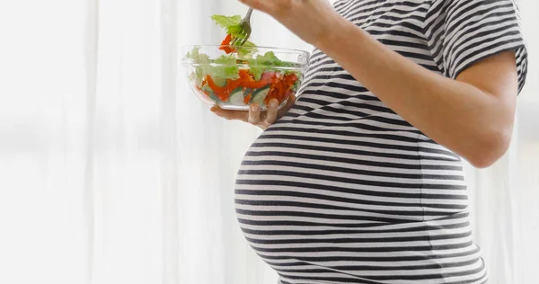 Wanita hamil makan tanaman salad — Stok Foto