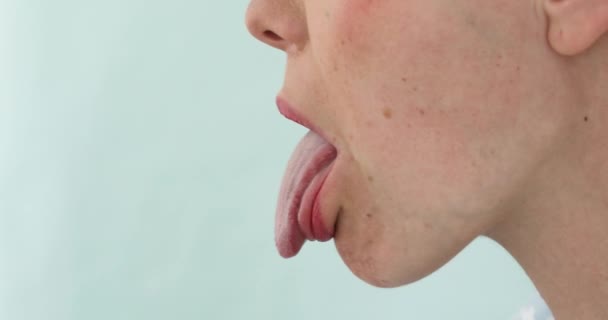 Закрытие женщины, показывающей вид на язык сбоку — стоковое видео
