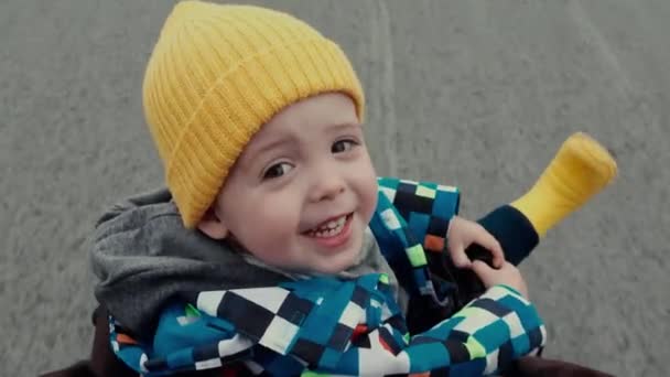 Pequeño niño carro de bebé en sombrero amarillo y botas — Vídeos de Stock