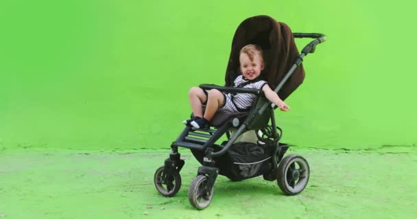 Portret van schattig kind in kinderwagen op straat — Stockvideo