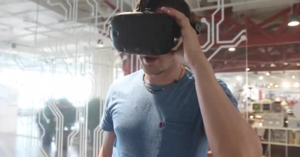 Людина використовує окуляри віртуальної реальності, а потім знімає гарнітуру для окулярів VR — стокове відео