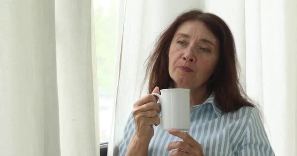 Ώριμη γυναίκα συλλογισμένος με φλιτζάνι καφέ — Αρχείο Βίντεο