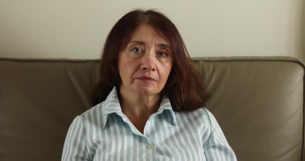 Portrait of a senior woman sitting on her sofa — Stock Video