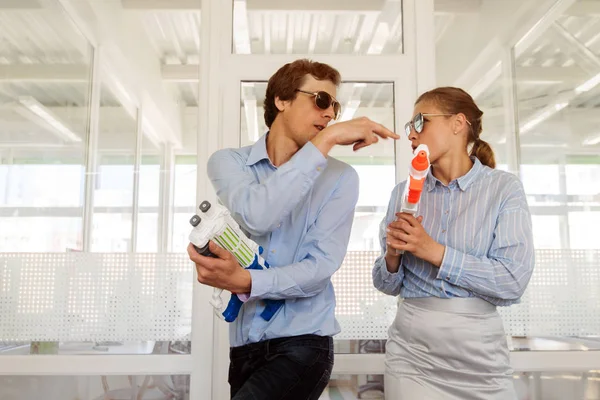 Playful colleagues with toy guns