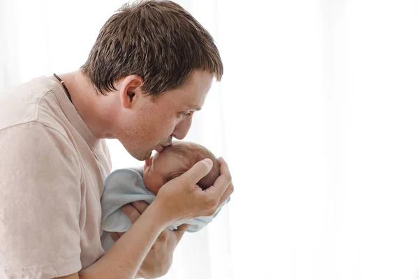 Отец обнимает и целует своего новорожденного ребенка — стоковое фото