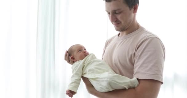 Осторожный отец с новорожденным ребенком на руках — стоковое видео