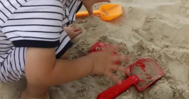 Kum oyuncakları oynarken Childs'ın eli yakın çekim
