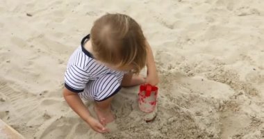 Kumda oynayan genç çocuk