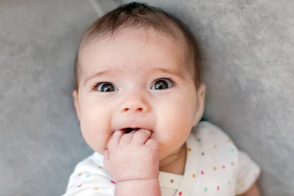 面白い赤ちゃんの指をかむ — ストック写真