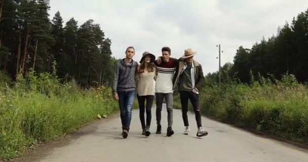 Jonge vrienden lopen op weg van het platteland — Stockvideo