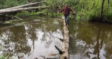 Adam bir kütük üstünde yürüyor