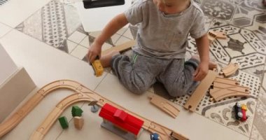 İki yıl yaşlı erkek çocuk ahşap demiryolu ile çalış.