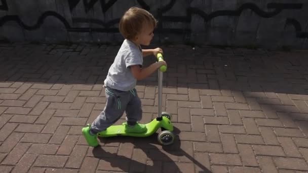 Niño montando verde patada scooter — Vídeos de Stock