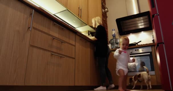 Modern matlagning nära hennes baby spelar — Stockvideo