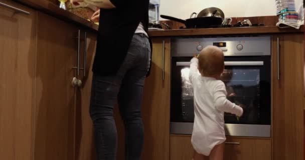 Mamma cucina vicino al suo bambino gioca — Video Stock
